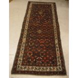 A Malayer runner, the central panel set with stylised floral motifs on a dark blue ground,