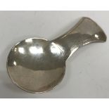 An Elizabeth II Arts & Crafts style silver caddy spoon with hammered decoration (by William Henry