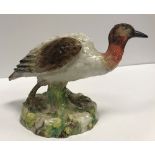 An early 19th Century Kändler style figure of an exotic bird on a mossy base,