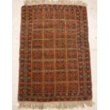 A Turkamen rug, the central panel set with repeating tiled decoration on a red ground,