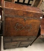 A studded brown leather covered bureau in the Spanish or Portugese taste,