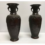 A pair of Japanese Meiji period chocolate patinated bronze vases with flared rims and mythical