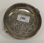 A George III silver lemon strainer, the pierced bowl within a reeded rim,