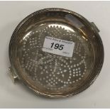 A George III silver lemon strainer, the pierced bowl within a reeded rim,