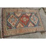 A Turkish carpet, the central panel set with three repeating medallions on a blue ground,