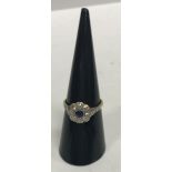 An 18 carat and platinum set ladies flower head ring with central sapphire (approx 0.