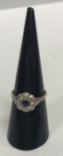 An 18 carat and platinum set ladies flower head ring with central sapphire (approx 0.