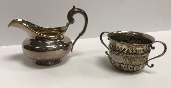 A William IV silver cream jug of bellied form with acanthus thumbpiece to the C scroll handle,