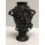 A Japanese Meiji period chocolate patinated bronze vase decorated in high relief with grape and