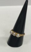 An 18 carat gold mounted three stone pearl dress ring, the pearls approx size 2.