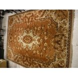 An Oriental carpet, the central panel set with foliate decorated medallion on a gold ground,