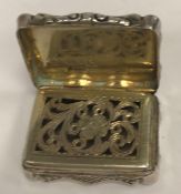 A Victorian silver foliate engraved vinaigrette of shaped rectangular form with waisted sides,