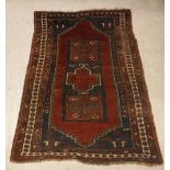 A Caucasian rug, the central panel set with rectangular medallion on a red ground,