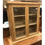 A pitch pine glazed two door cupboard, 78 cm wide x 30.5 cm deep x 84.