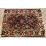 A Caucasian rug, the central panel set with central floral motif,