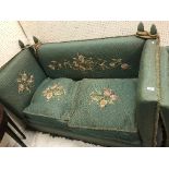An early 20th Century green upholstered and floral spray needlework decorated Knowle sofa of