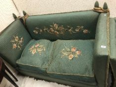 An early 20th Century green upholstered and floral spray needlework decorated Knowle sofa of