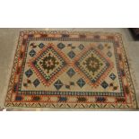 A Turkish carpet, the central panel set with two repeating medallions on a cream ground,