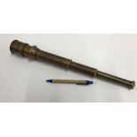 A modern reproduction decorative brass three draw telescope with engraved floral decoration and