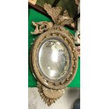 A 19th Century convex wall mirror with spreadeagle surmount and ball decoration to the frame,