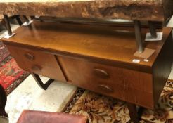 A 1960's teak dressing chest with mirrored back over a bank of four drawers with solid navette