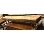 A rustic pig bench style stool on splayed supports, approx 169 cm wide x 28 cm deep x 33.