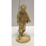 A 19th Century Japanese Meiji period carved ivory okimono as a man with staff and fruit in his hand,