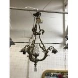 An early 20th Century brass three branch ceiling light with stylised flower head decoration and