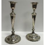 A near-matching pair of candlesticks in the Regency style with fluted decoration,
