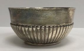 A George III silver circular bowl with semi-reeded decoration and engraved shield shaped armorial