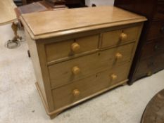 A Victorian pine chest of two short over two long drawers with turned knob handles raised on