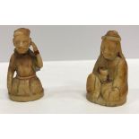 A pair of 19th Century Indian carved ivory figures of a seated gentleman,