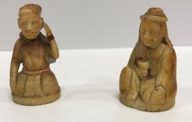 A pair of 19th Century Indian carved ivory figures of a seated gentleman,