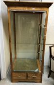 A modern ash veneered framed display cabinet the foreglass glazed top enclosing glass shelves and