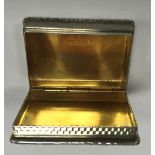 A mid 20th Century silver and engine-turned pill box of rectangular form with raised cast foliate