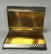 A mid 20th Century silver and engine-turned pill box of rectangular form with raised cast foliate