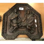 A 17th Century wooden plaque depicting female and male angels within a shaped border,