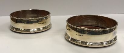 A pair of silver bottle coasters with rope-twist rims over slightly bellied sides and reeded framed