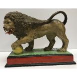 An early 19th Century Pearlware polychrome decorated figure of a Lion with foot upon ball,