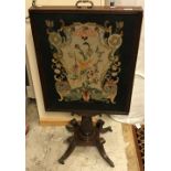 An early 19th Century mahogany framed needlework tapestry panelled adjustable fire screen with