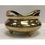 A Chinese bronze censer with openwork handles, raised on three feet,