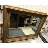 A circa 1900 gilt gesso rectangular swept framed wall mirror with plain plate 128 cm x 101 cm