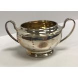 A George V silver sugar basin with gilt-washed interior flanked by open handles,