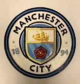 A modern painted cast iron sign inscribed "Manchester City",