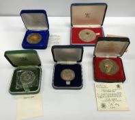 A collection of various commemorative coinage including a 25th Anniversary medallion celebrating