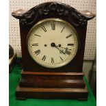An early Victorian mahogany cased mantel clock with oak leaf and acorn decorated cornice over the