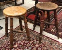 A Victorian beech circular stool on turned legs united by an X-stretcher together with a similar