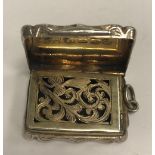 A Victorian silver and engraved vinaigrette of shaped rectangular form with waisted sides,