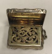 A Victorian silver and engraved vinaigrette of shaped rectangular form with waisted sides,