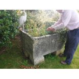A large natural stone rectangular trough raised on four block bases,